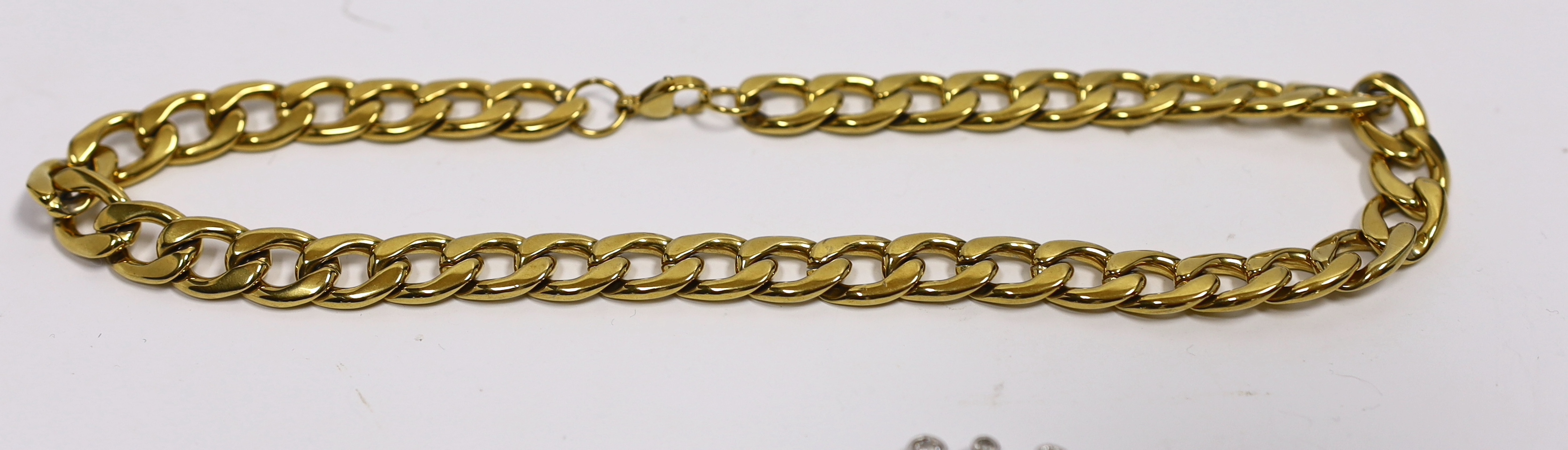 A gilt metal curblink necklace, a white metal paste set bracelet stamped 925 and a rock crystal pendant with gilt metal loop